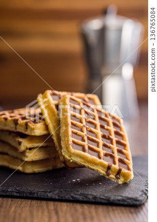 Sweet waffles with chocolate on wooden table. 136765084