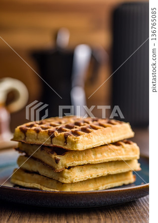 Sweet waffles with chocolate on plate on wooden table. 136765085