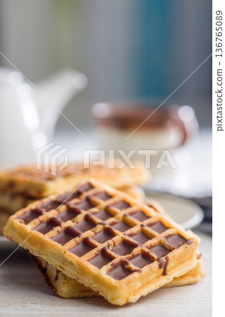 Sweet waffles with chocolate on kitchen table. 136765089