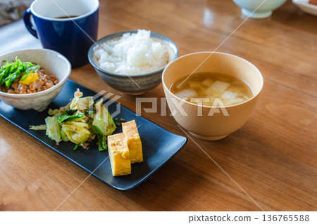 Japanese breakfast set of natto rice and miso soup, with tamagoyaki egg, vegetable side dish, and coffee 136765588