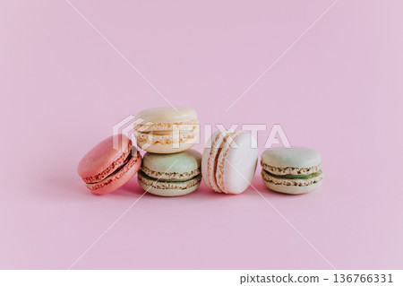Tasty french macarons on a pink pastel background. 136766331