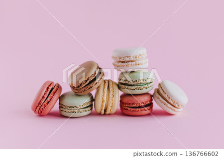 Tasty french macarons on a pink pastel background. 136766602