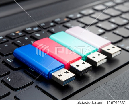 鍵盤上擺放著四個不同顏色的U盤。 136766881