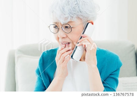 Senior woman talking on landline phone Senior woman talking on landline phone 136767578
