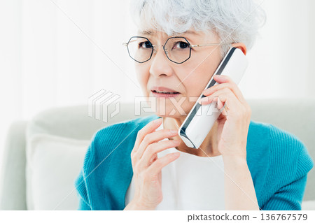 Senior woman talking on landline phone Senior woman talking on landline phone 136767579