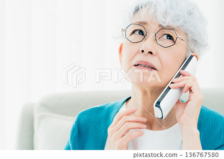Senior woman talking on landline phone Senior woman talking on landline phone 136767580