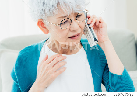 Senior woman talking on landline phone Senior woman talking on landline phone 136767583