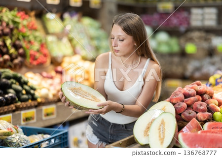 Young woman shopping in vegetable store and buy melon Young woman shopping in vegetable store and buy melon 136768777