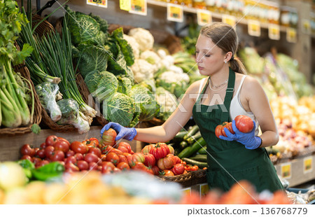 female seller lays out tomatoes on the counter female seller lays out tomatoes on the counter 136768779