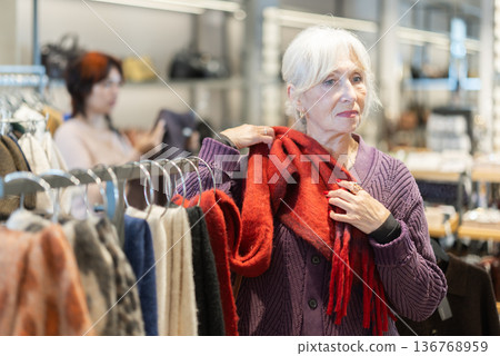 Senior woman at trading floor pick out and buying scarf. Senior woman at trading floor pick out and buying scarf. 136768959