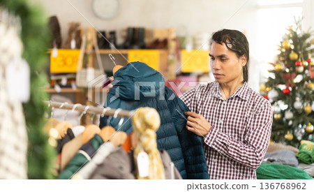 In chain shop, Indonesian man choose down jacket, X mas shopping 136768962