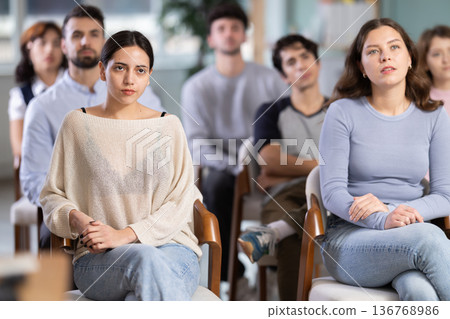 Group of young students listening during seminar in a modern classroom Group of young students listening during seminar in a modern classroom 136768986