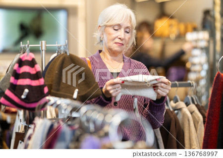 Mature woman choosing high quality hats in the store 136768997