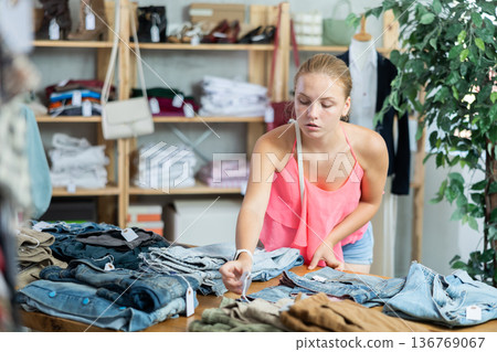 woman carefully chooses jeans 136769067