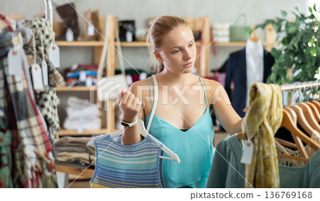 Joyful woman choosing tops in store Joyful woman choosing tops in store 136769168