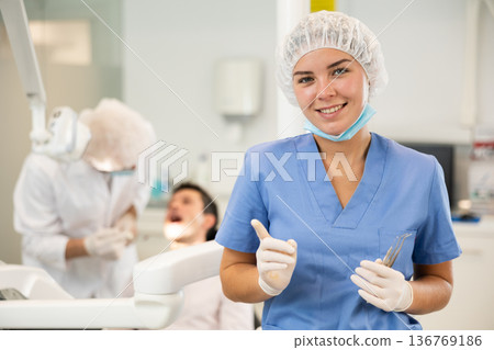 Young woman nurse in blue suit is standing in dental office, clinic 136769186