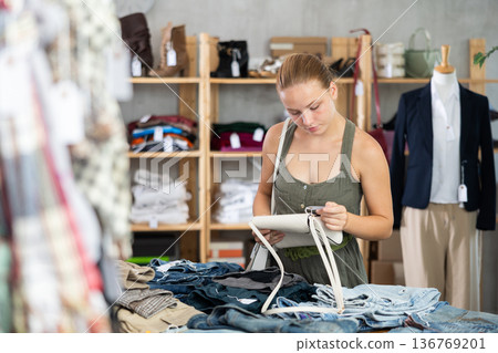 Teenage girl choosing handbag in store Teenage girl choosing handbag in store 136769201
