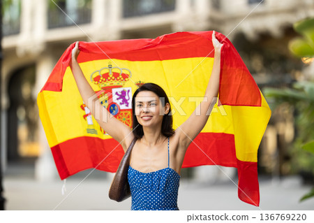 Young woman with spanish flag on city street Young woman with spanish flag on city street 136769220