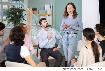 Guys and girls are sitting in circle and listening to one of their girl friend classmate Guys and girls are sitting in circle and listening to one of their girl friend classmate 136769234