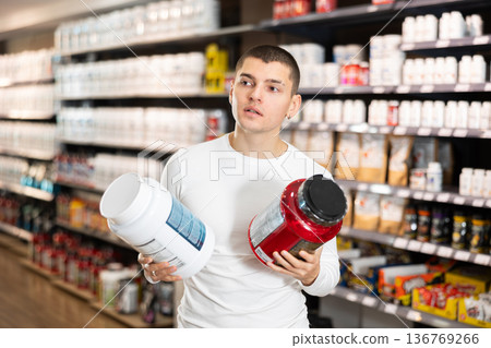 Young man buying jar of sports nutrition Young man buying jar of sports nutrition 136769266