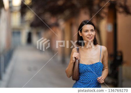 Young woman looks around on city street Young woman looks around on city street 136769270