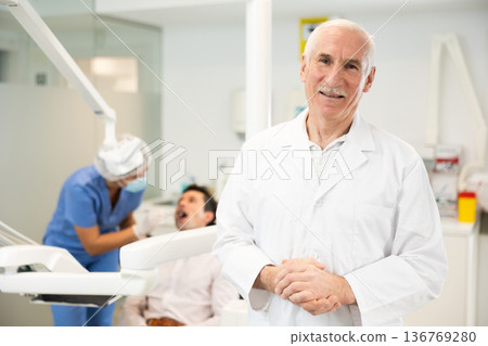 Senior man doctor is standing in dental office, clinic 136769280