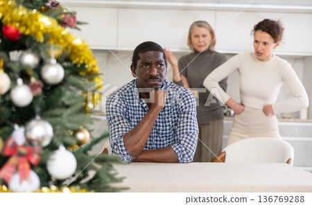 Two women, mother-in-law and wife, scold man during their New Year celebration Two women, mother-in-law and wife, scold man during their New Year celebration 136769288