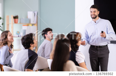 man stands with a remote control in front of students 136769302
