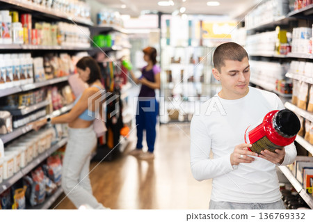 Young man buying jar of sports nutrition Young man buying jar of sports nutrition 136769332