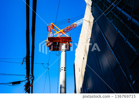 Apartment building construction in the city, tower cranes and power lines a-2 High saturation contrast 136769715