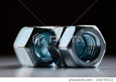Detailed close up of chrome plated internal thread fasteners with shallow depth of field 136770132