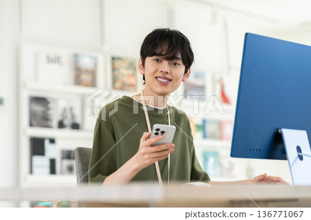 A young male engineer using a smartphone in the office A young male engineer using a smartphone in the office 136771067
