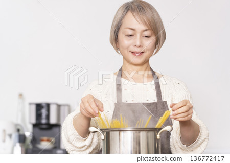 老婦人在廚房煮義大利麵 老婦人在廚房煮義大利麵 136772417