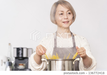 老婦人在廚房煮義大利麵 老婦人在廚房煮義大利麵 136772418