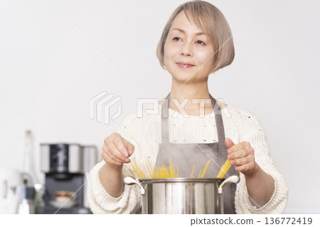 老婦人在廚房煮義大利麵 老婦人在廚房煮義大利麵 136772419