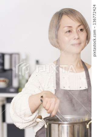 老婦人在廚房煮義大利麵 老婦人在廚房煮義大利麵 136772424
