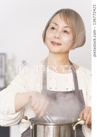 老婦人在廚房煮義大利麵 老婦人在廚房煮義大利麵 136772425