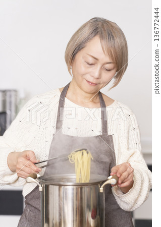 老婦人在廚房煮義大利麵 老婦人在廚房煮義大利麵 136772444