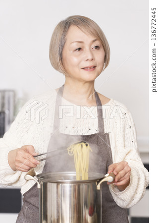 老婦人在廚房煮義大利麵 老婦人在廚房煮義大利麵 136772445