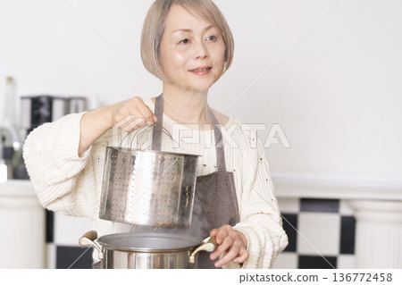 老婦人在廚房煮義大利麵 老婦人在廚房煮義大利麵 136772458