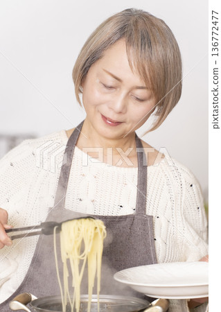 老婦人在廚房煮義大利麵 老婦人在廚房煮義大利麵 136772477
