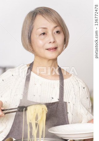 老婦人在廚房煮義大利麵 老婦人在廚房煮義大利麵 136772478