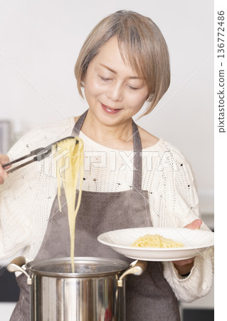 老婦人在廚房煮義大利麵 136772486