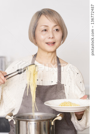 老婦人在廚房煮義大利麵 136772487