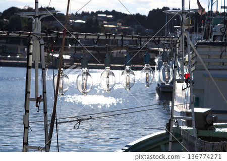停泊在港口的魷魚捕撈船上的捕魚燈 136774271