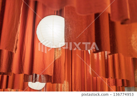 橘色窗簾前方懸掛著圓形紙質吊燈 橘色窗簾前方懸掛著圓形紙質吊燈 136774953