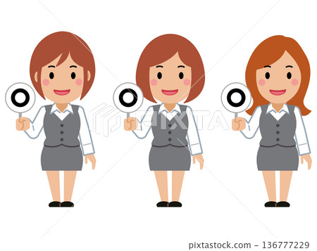 A young woman in gray office wear holding up the correct answer card A young woman in gray office wear holding up the correct answer card 136777229