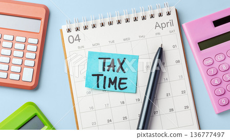 Sticky note with tax time word on calendar with calculators and pen on light blue background, tax payment due, tax season concept Sticky note with tax time word on calendar with calculators and pen on light blue background, tax payment due, tax season concept 136777497