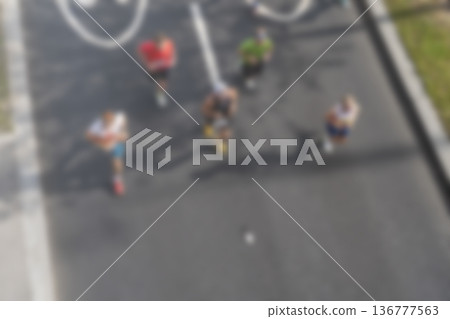 A blurry image of a group of people running down a street A blurry image of a group of people running down a street 136777563