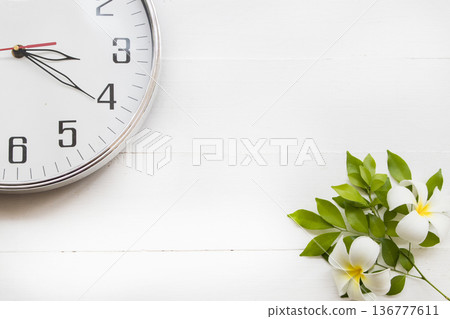white clock in afternoon with flowers frangipani arrangement flat lay postcard style 136777611